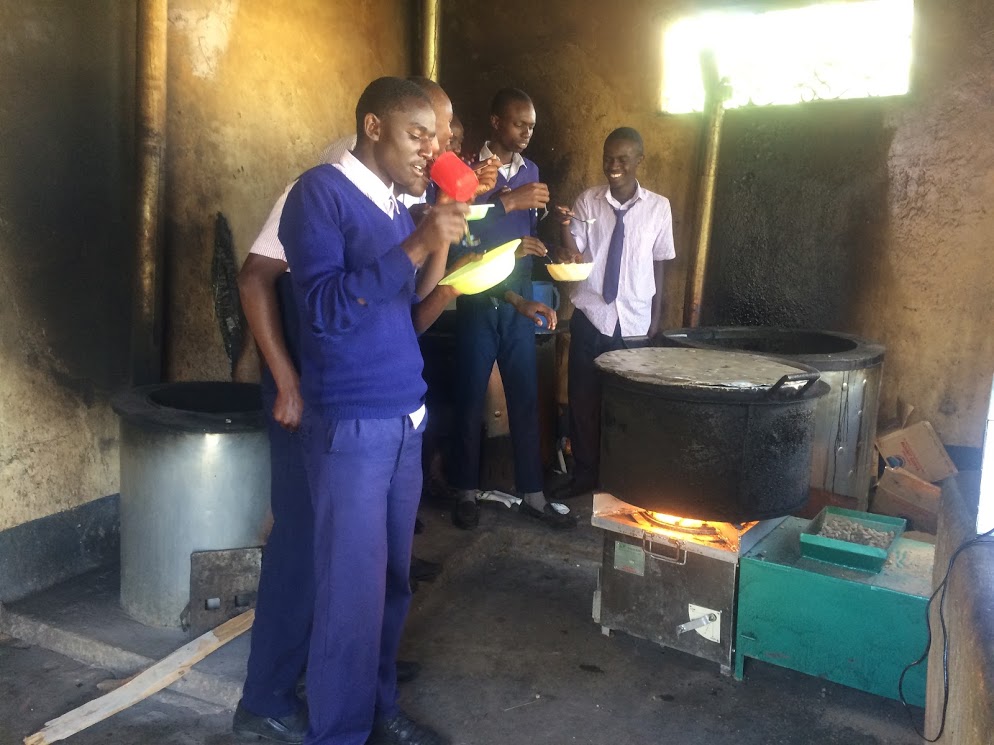 Katumani Secondary Pupils in awe of the stove and eating food prepared using the stove